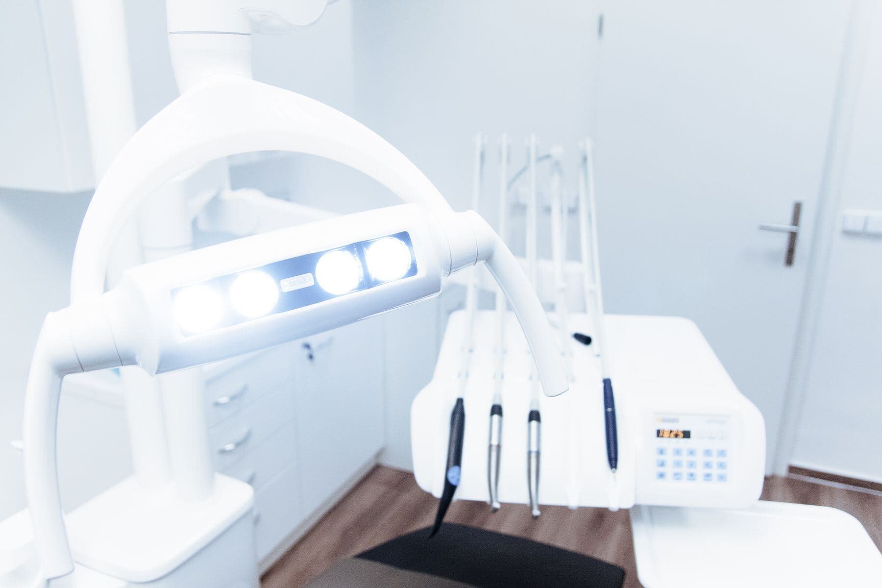Behandlungsleuchte und Instrumente in einem hellen Behandlungszimmer